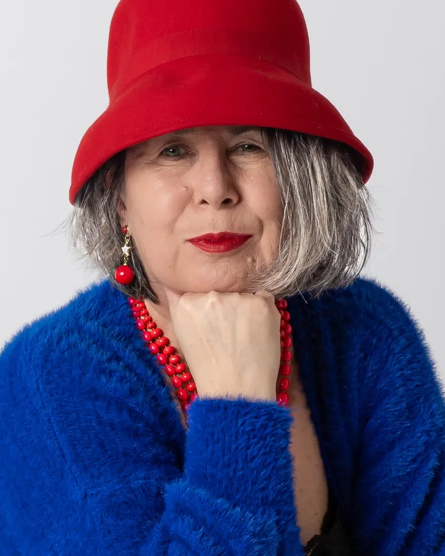 Donna con cappello rosso e cardigan blu, mento appoggiato sul pugno, ritratto di Ilia Da Lozzo